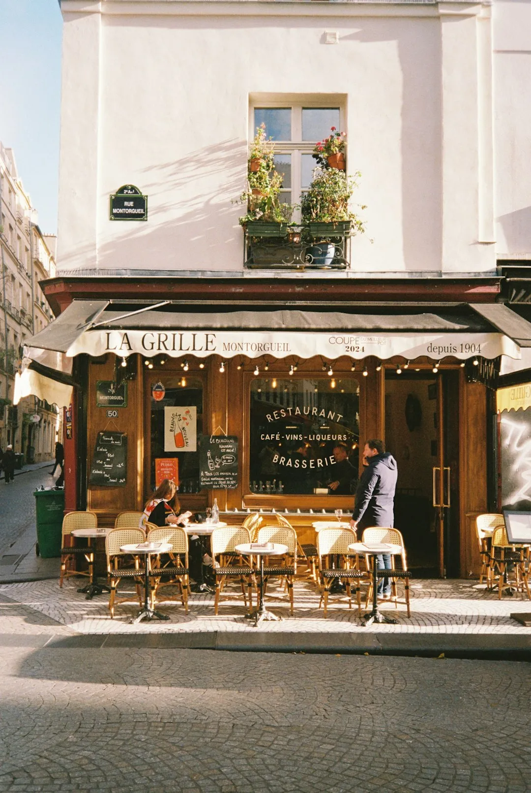 People sit at tables outside a parisian restaurant
